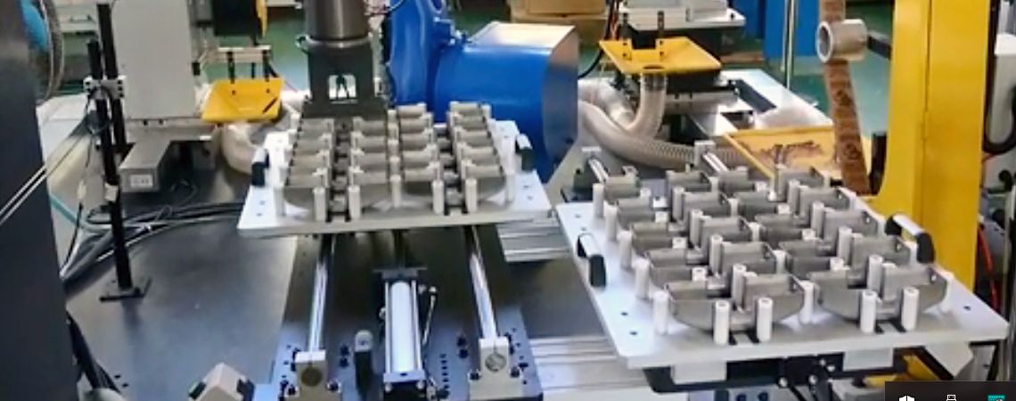 Il braccio robotico YASKAWA MH50 collabora con sistemi di alimentazione a tavolo scorrevole per l'automazione della lucidatura