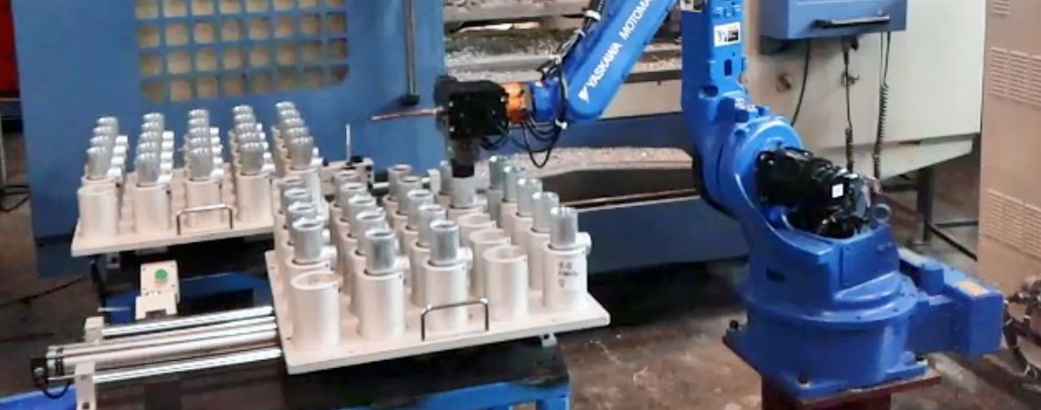 Il braccio robotico YASKAWA MH6 collabora con sistemi di alimentazione a tavolo scorrevole per automatizzare la gestione delle macchine